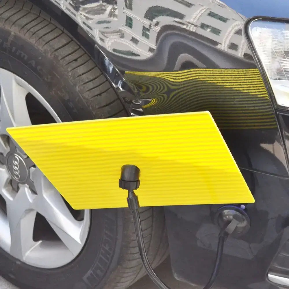 Bright yellow, ribbed plastic car bumper cover with a black charging cable attached.
