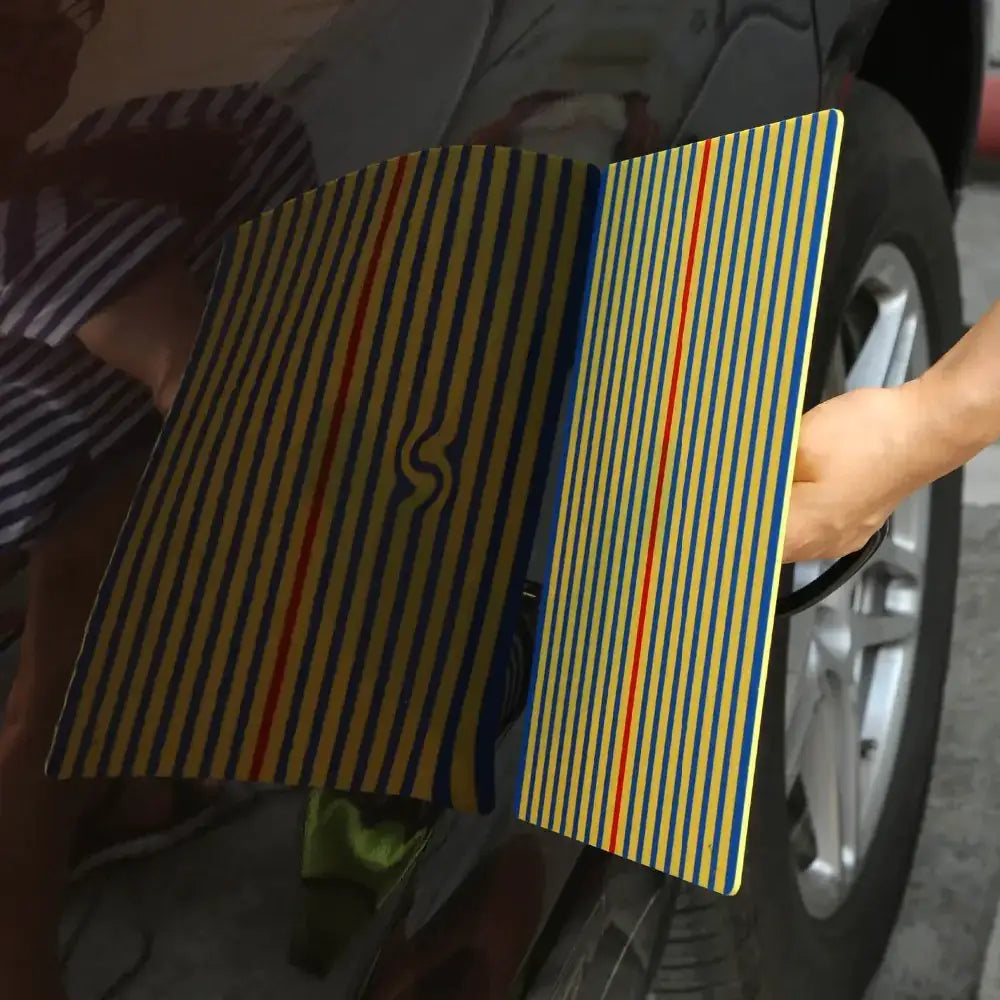 A vibrant yellow, blue, and red striped folding measuring board with a sleek black handle.