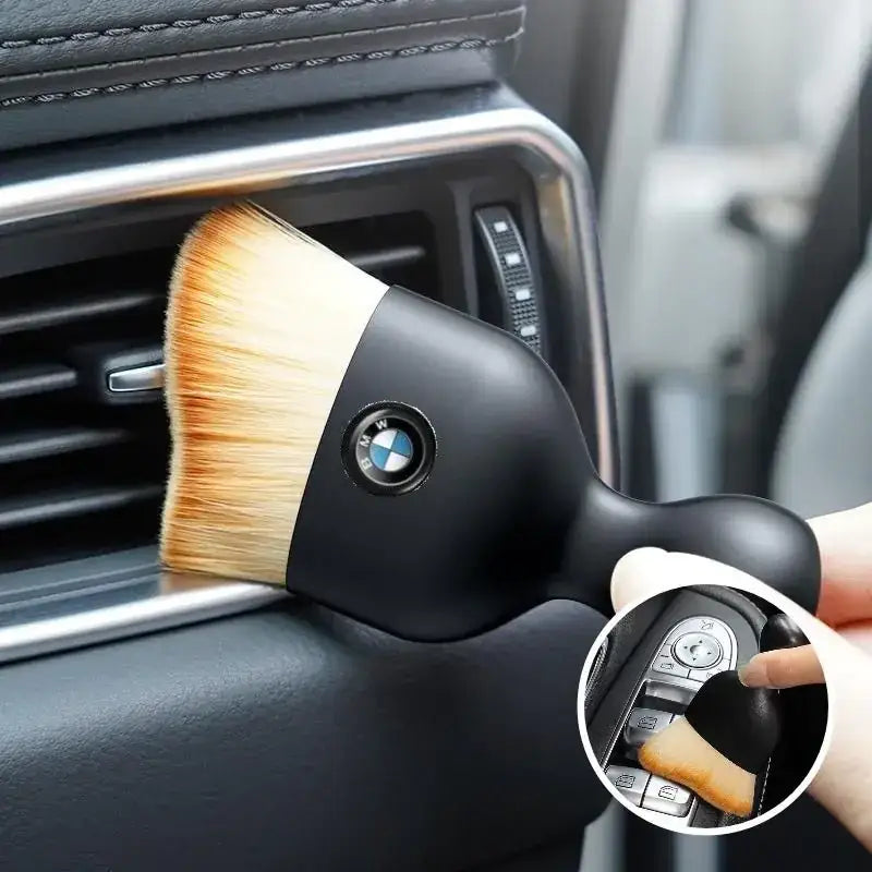 Black bmw-branded car air vent brush with soft, light brown bristles.