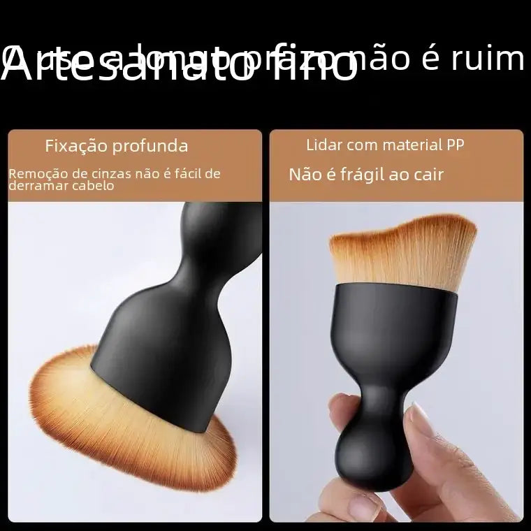 Black plastic-handled makeup brush with dense, light brown synthetic bristles designed for applying foundation or powder.