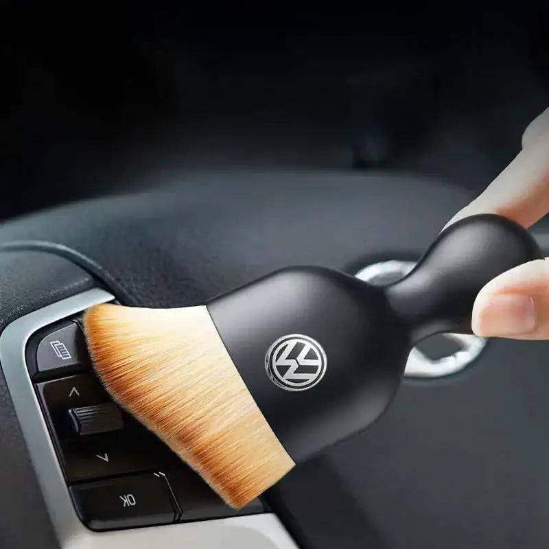 Black volkswagen-branded car interior cleaning brush with soft, light brown bristles.