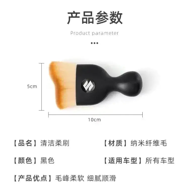 Black car cleaning brush with soft, orange-tipped nano-fiber bristles and a sleek ergonomic handle.