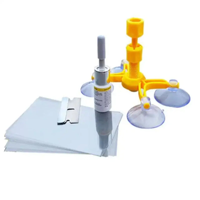 Yellow suction cup window cleaning tool with a silver and white spray bottle nearby