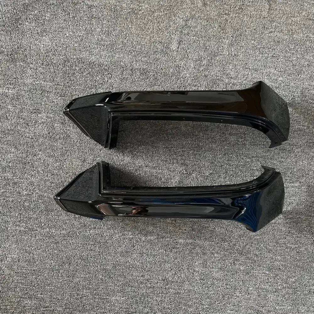 Black glossy plastic car door handle trim pieces.
