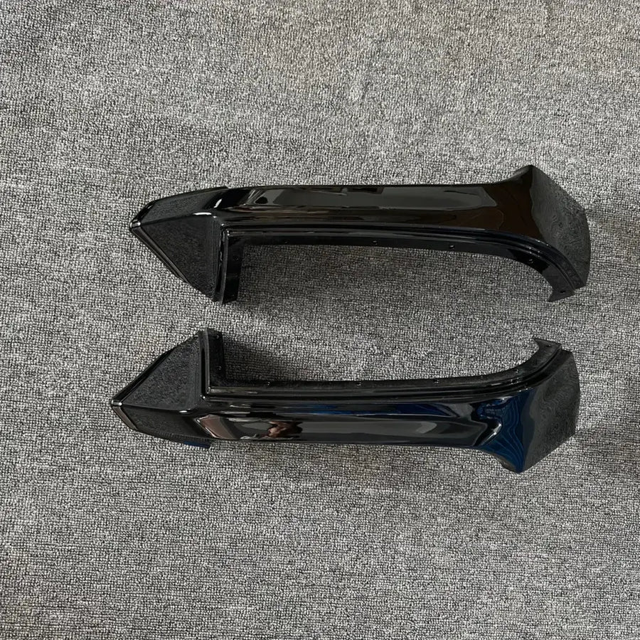 Black glossy plastic car door handle trim pieces.