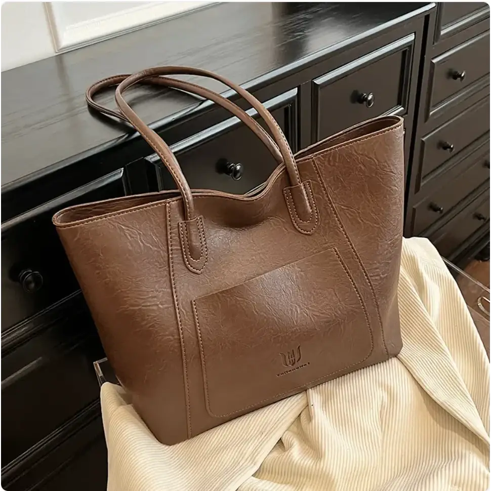 Brown faux leather tote bag with a textured surface and matching handles.