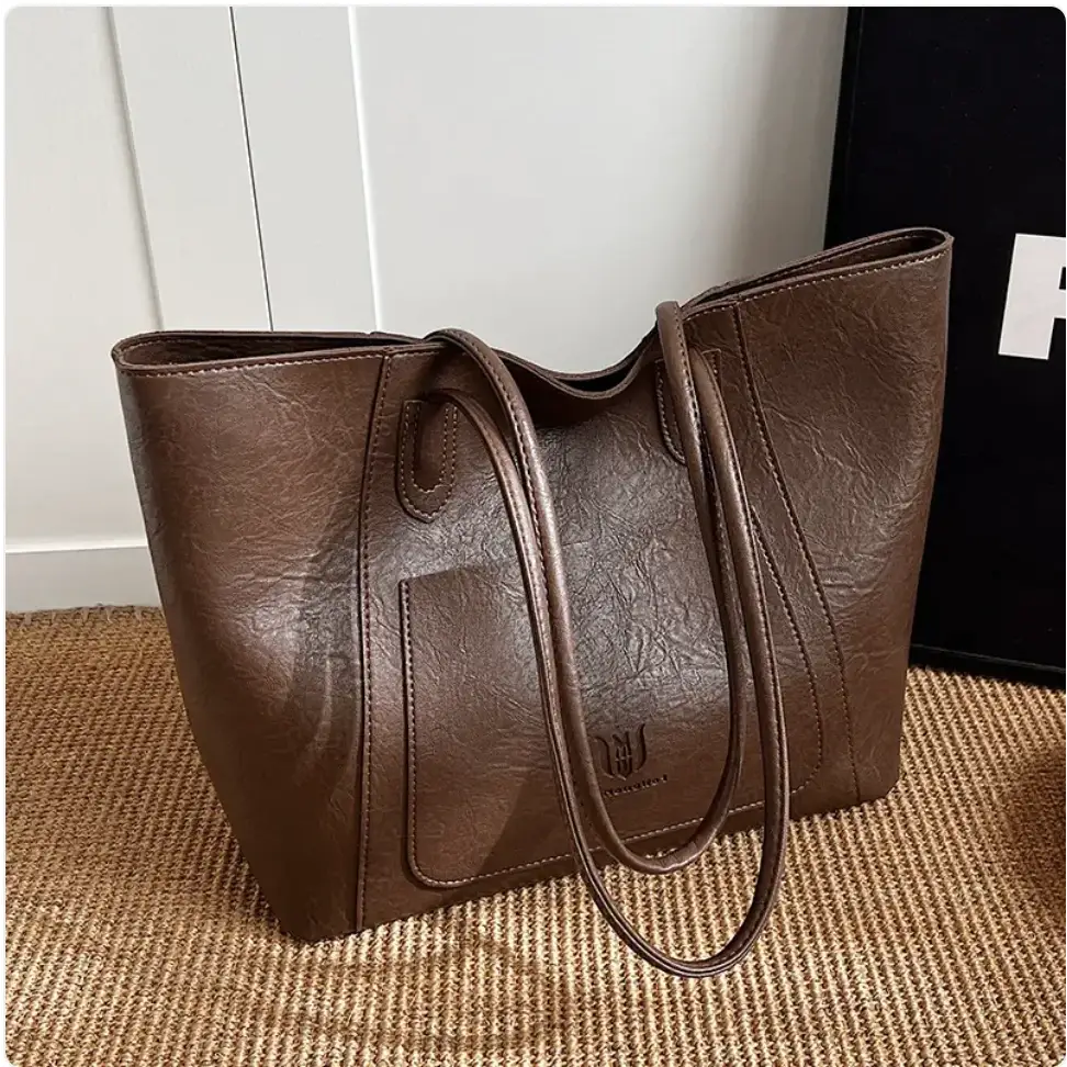 Brown faux leather tote bag with a textured surface and matching handles.