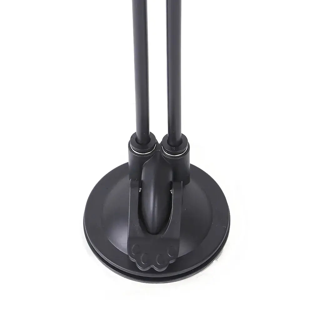 Black dual-armed desk lamp with a circular suction base and sleek, matte-finished metal poles.