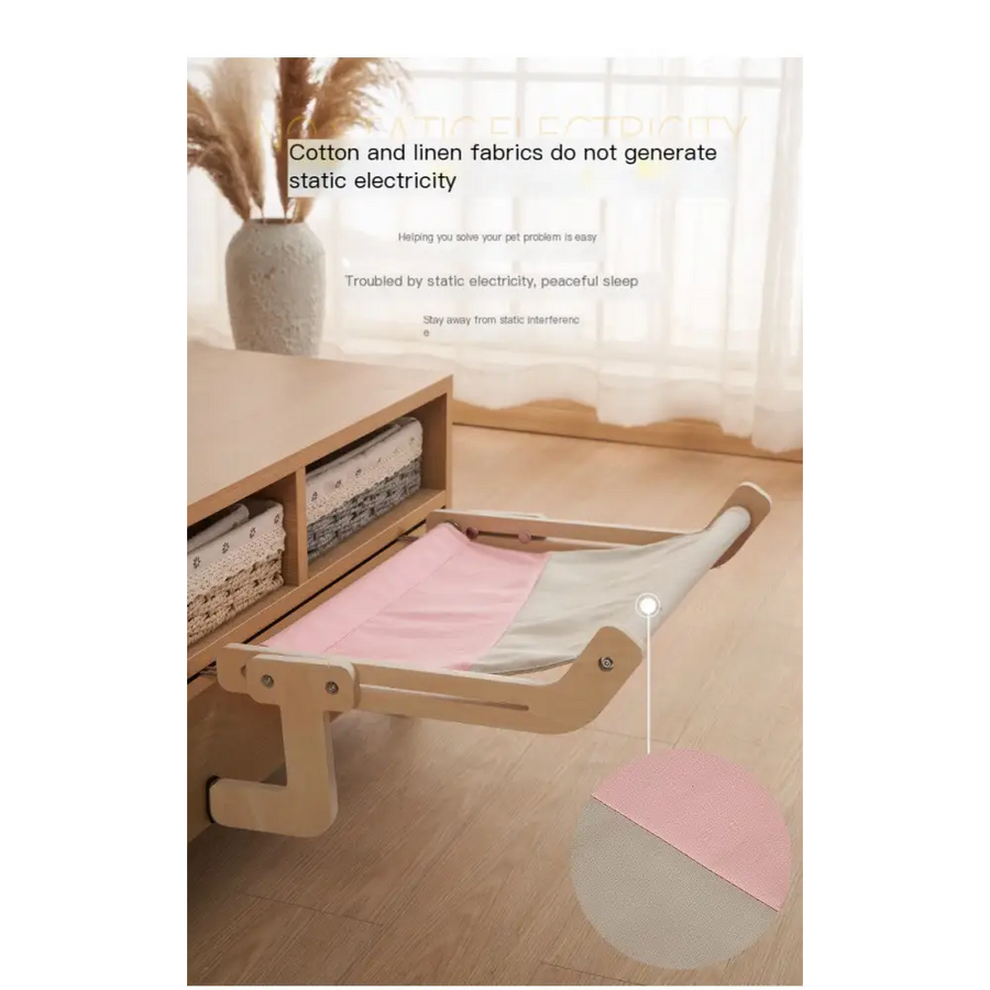 A light pink and gray fabric pet bed with a wooden frame, designed for hanging from furniture.