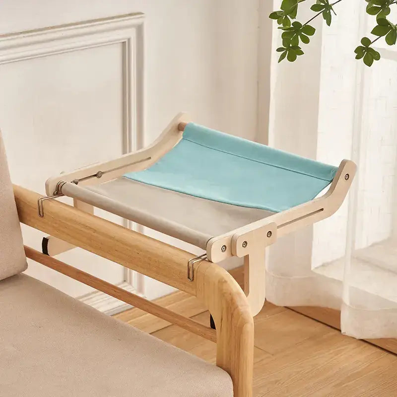 Light wood-framed cat bed with a two-tone fabric surface in soft beige and mint green.