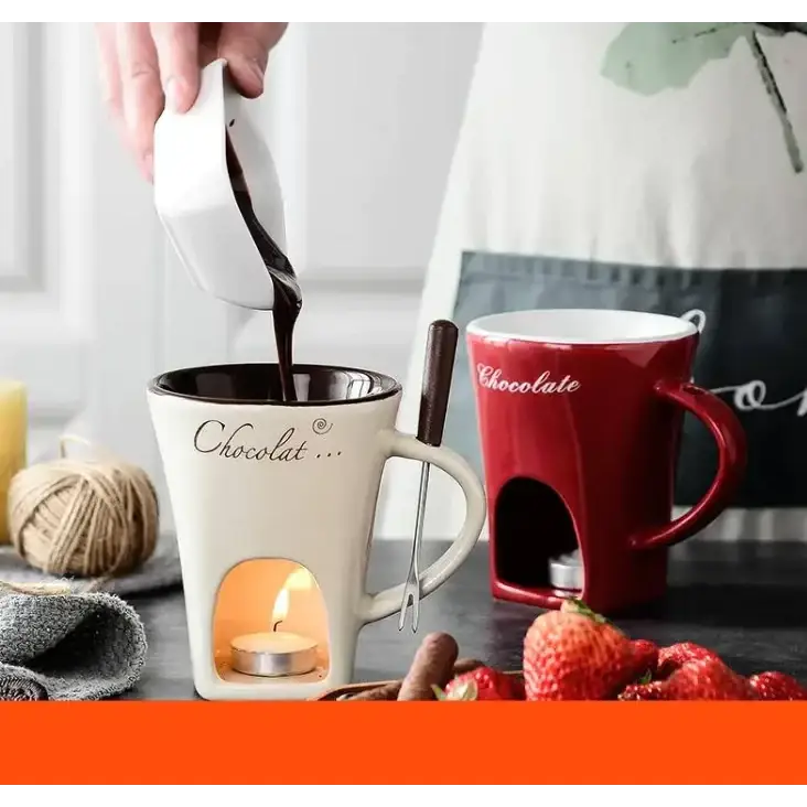 Cream-colored ceramic chocolate fondue mug with a built-in candle holder and ’chocolat...’ scripted in black.