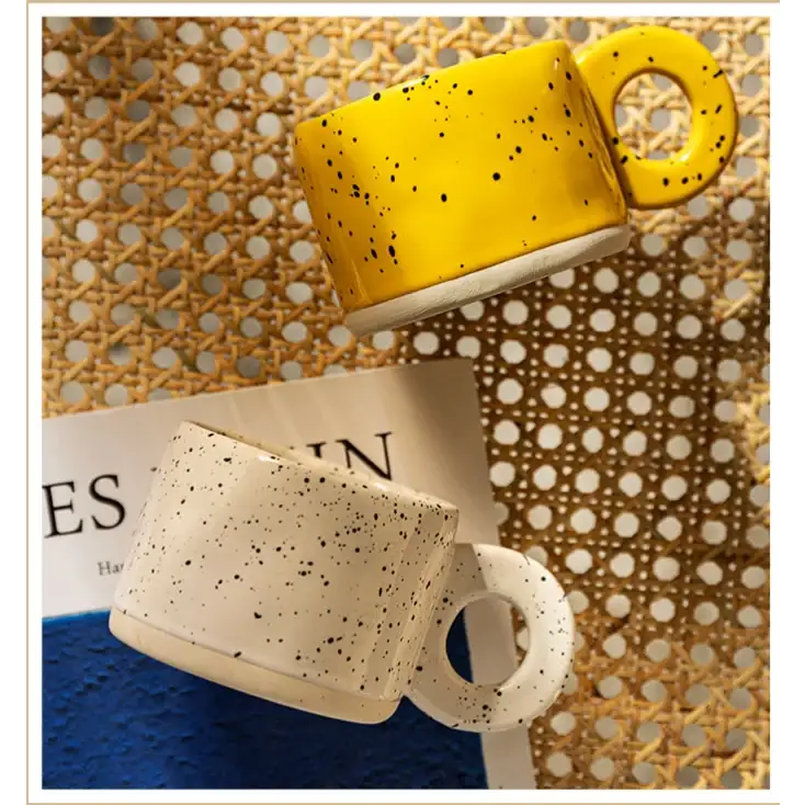 Yellow speckled ceramic mug with a white base and handle