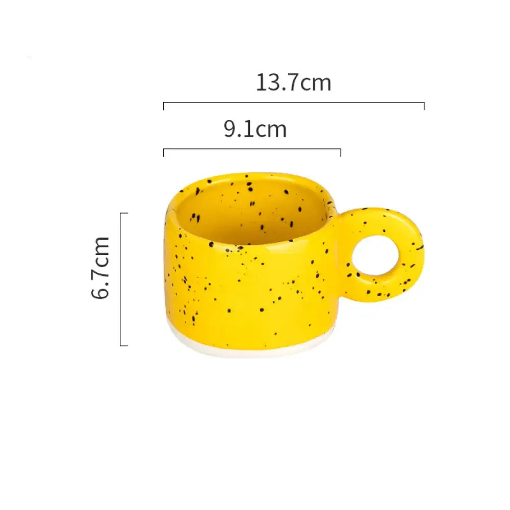 A vibrant yellow ceramic mug with black speckles and a matching handle, measuring 13.7cm in length, 9.1cm in width, and 6.7cm in height.