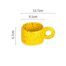A vibrant yellow ceramic mug with black speckles and a matching handle, measuring 13.7cm in length, 9.1cm in width, and 6.7cm in height.