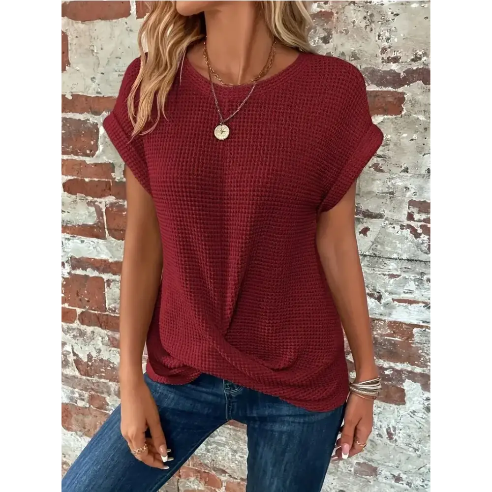 A cozy maroon waffle-knit short-sleeved top with a relaxed fit and subtle front twist detail.