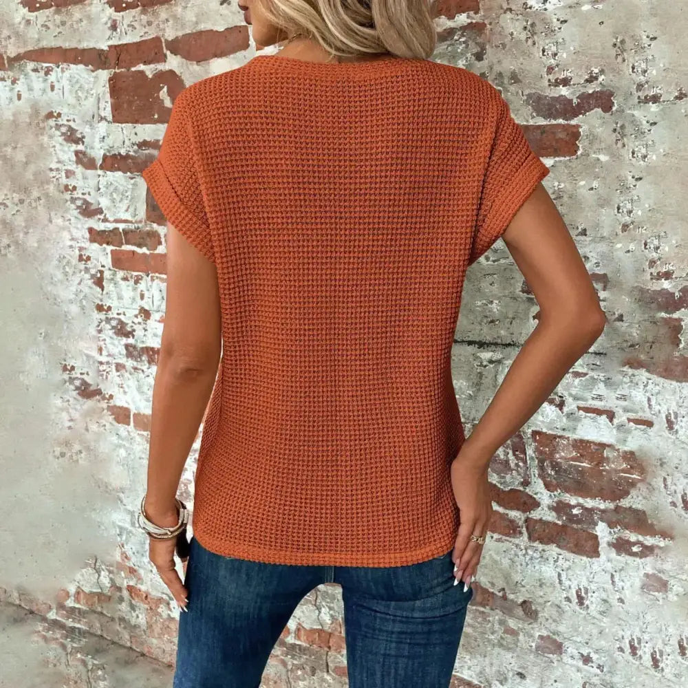 A rust-orange waffle-knit short-sleeved top with a relaxed fit.