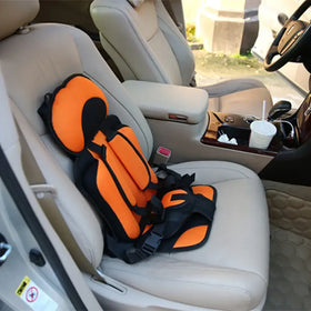 Bright orange and black child safety seat with padded headrest and adjustable straps, designed for secure car travel.
