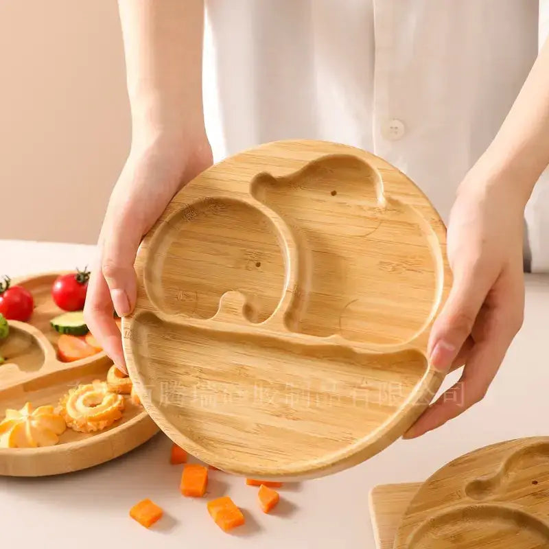 Light brown bamboo children’s plate shaped like a bear with carved compartments.