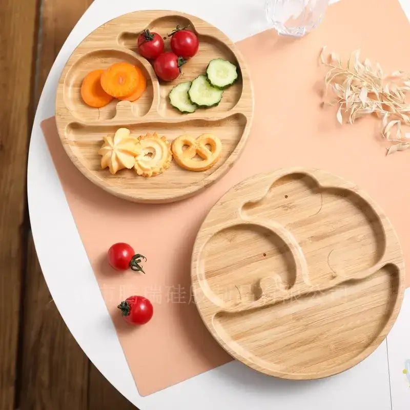 Light brown bamboo children’s meal plate with three compartments shaped like a smiling face.