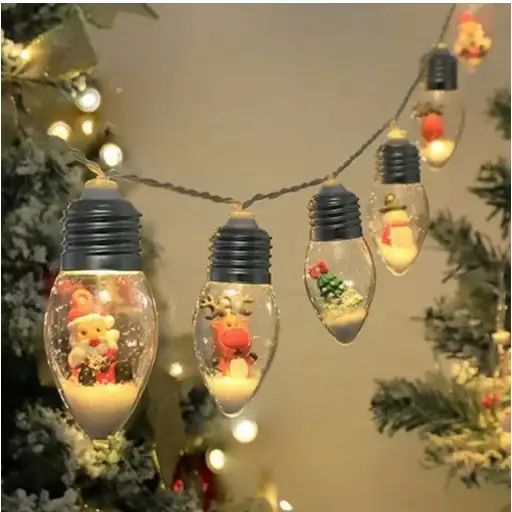 A string of clear glass christmas light bulbs, each featuring a black screw base and containing miniature festive figurines like santa claus or reindeer inside.