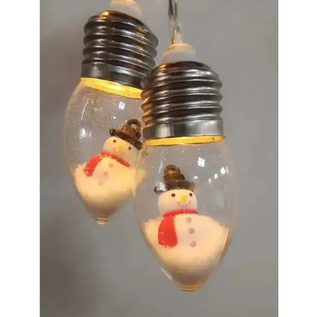 Clear glass light bulbs with silver screw bases, each containing a miniature snowman figurine wearing a brown hat and red scarf.