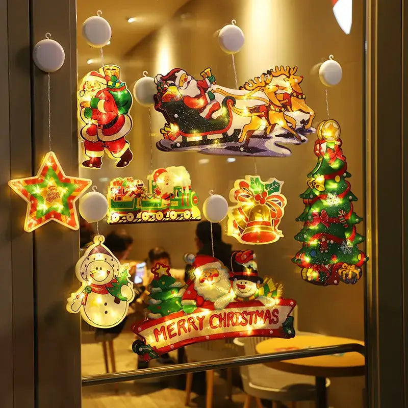 A festive collection of illuminated christmas-themed window decals featuring santa, reindeer, snowmen, a train, and a tree with glowing lights.
