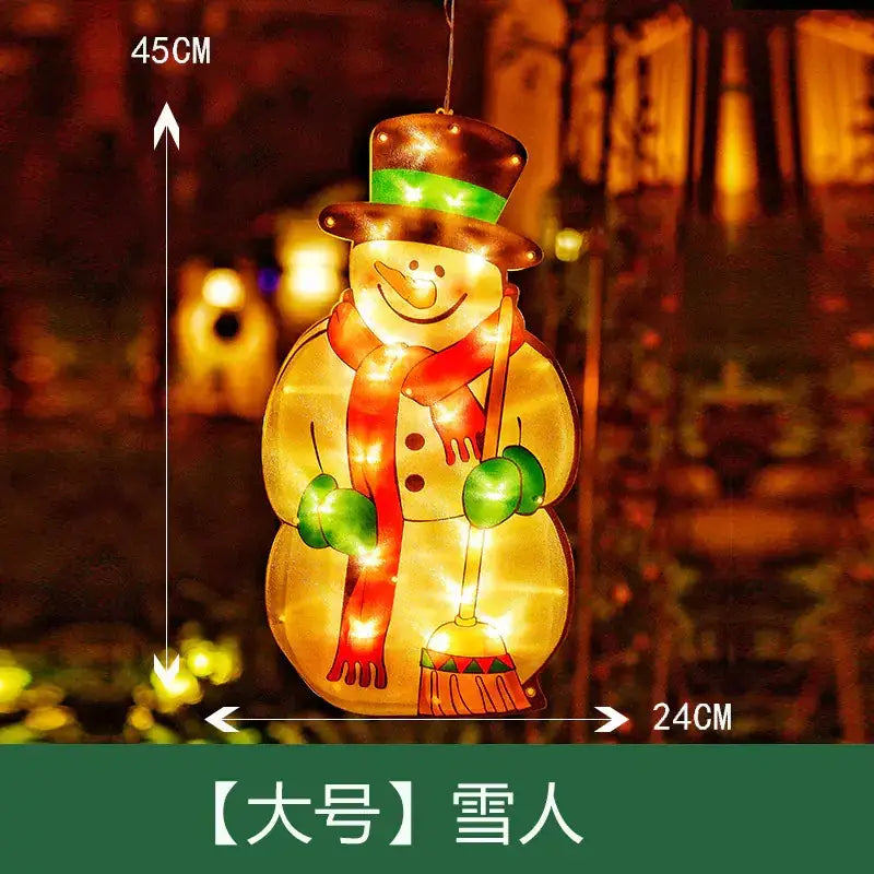 A glowing, illuminated snowman decoration with a brown top hat featuring a green band, red scarf, and green mittens, holding a broom that emits warm lights from within.