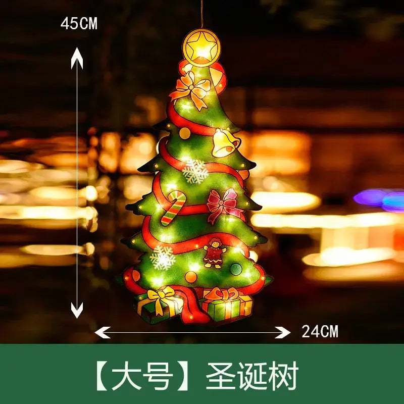 Green illuminated christmas tree ornament with red ribbons, gold bows, candy canes, snowflakes, bells, and presents, topped with a glowing star.