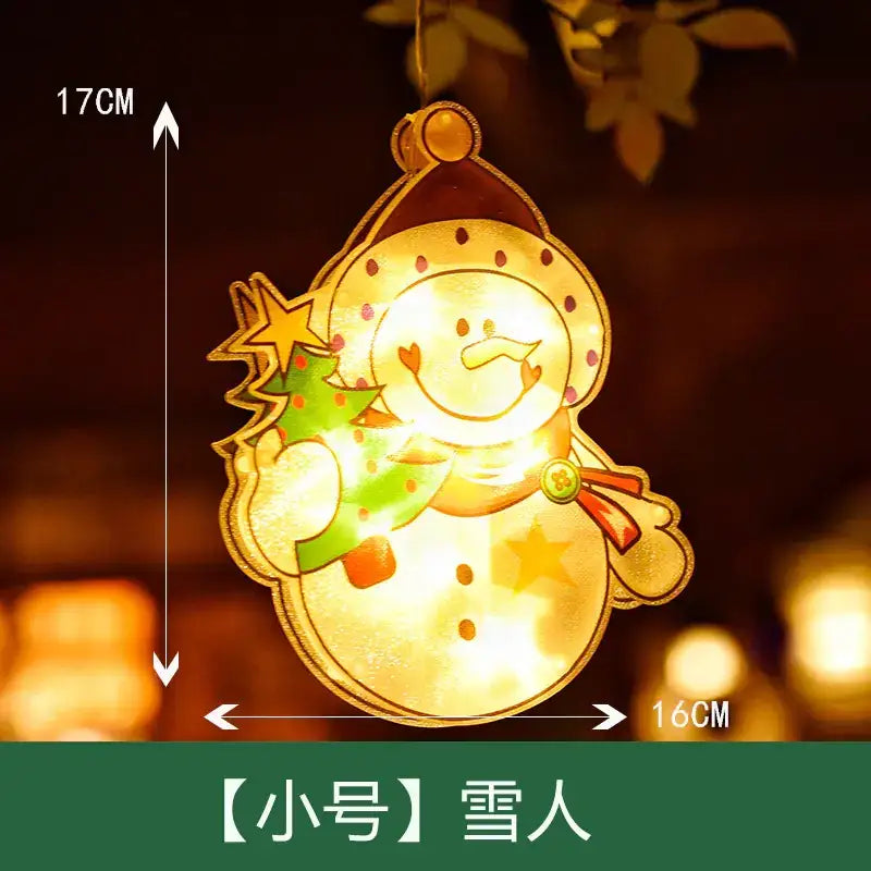 A glowing, illuminated snowman ornament with a smiling face, wearing a red hat and scarf, holding a green christmas tree, crafted from translucent material.