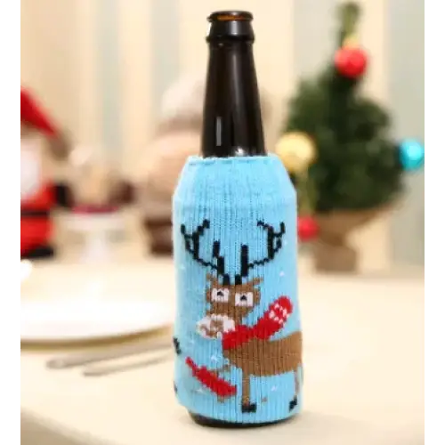 A light blue knitted bottle sleeve featuring a brown reindeer with antlers, holding red mittens and carrots.