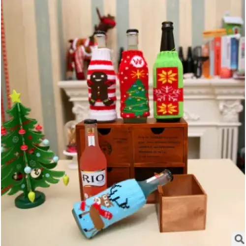 A festive blue wine bottle with a reindeer design and red scarf, wrapped in a knitted sweater-style cover.