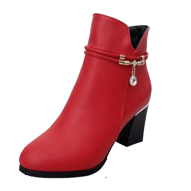 Red ankle boot with a glossy finish, featuring a black block heel and a decorative strap adorned with a dangling crystal teardrop charm.