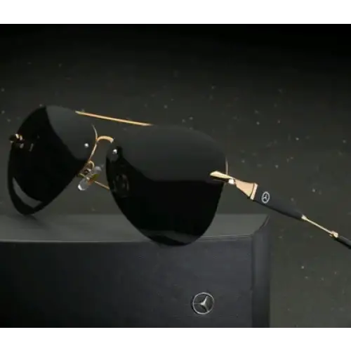 Black aviator sunglasses with gold-tone metal frames and a mercedes-benz logo on the temple.