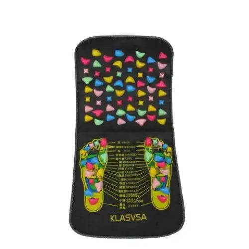 Black foot reflexology mat with colorful, raised beads arranged in a pattern over illustrated feet and labeled acupressure points.