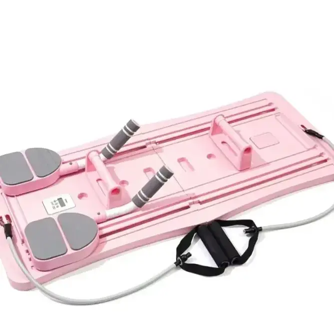 Pink plastic exercise board with gray foot pads and black resistance bands.