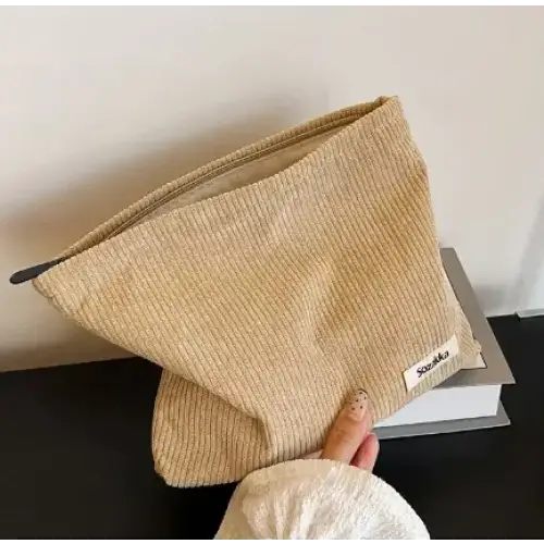 Beige corduroy zipper pouch with a small white label.