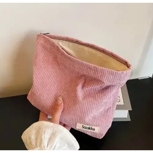 Pink corduroy makeup bag with a beige interior and a white label reading ’soczalka.’