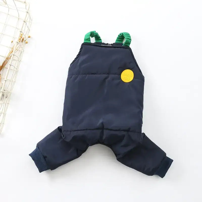 Navy blue quilted pet overalls with green elastic straps and a yellow circular patch