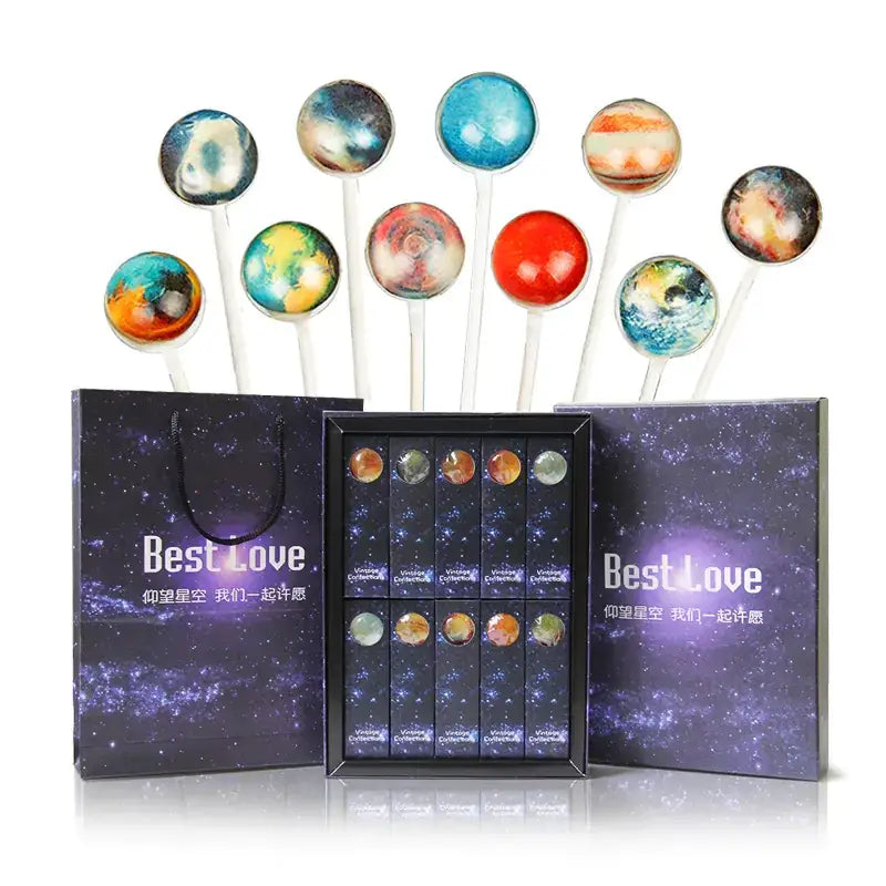 A set of planet-themed lollipops with colorful, glossy candy spheres on white sticks.