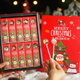 Red christmas-themed candy box with festive illustrations of santa claus and a tree, containing twelve individually wrapped lollipops.