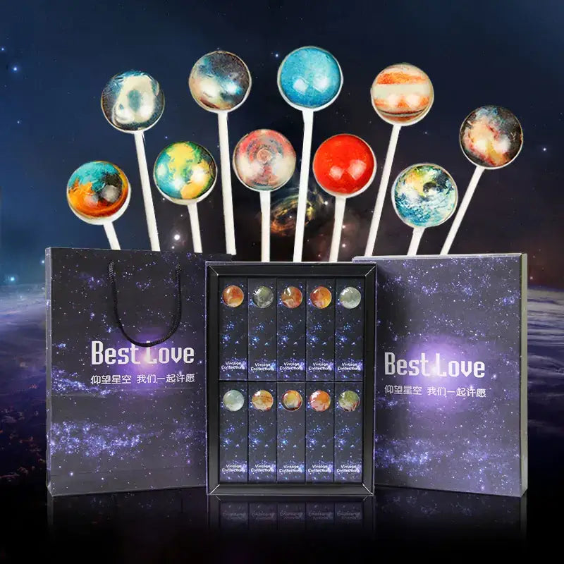 A set of planet-themed lollipops with glossy, colorful candy spheres on white sticks.