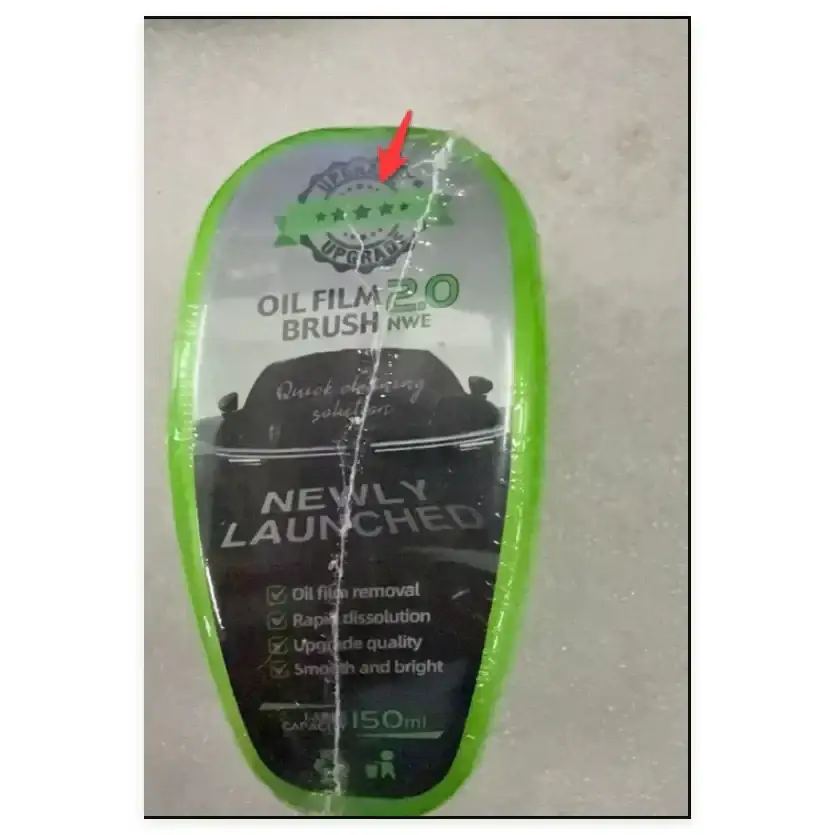 Green plastic oil film brush in clear packaging with a ’newly launched’ label and product features listed.