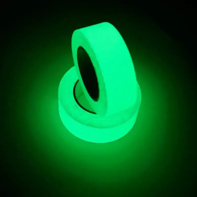 Two rolls of vibrant green glow-in-the-dark tape, emitting a bright luminescent light against a dark background.