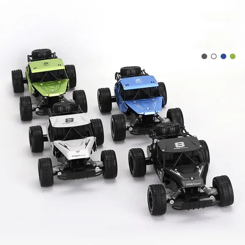 Four metallic remote-controlled off-road racing trucks in green, blue, white, and black with rugged tires and detailed chassis designs.