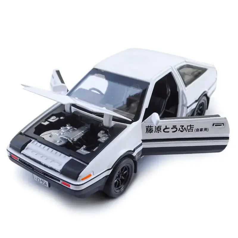 White die-cast model of a toyota ae86 with black accents and open doors, featuring japanese text on the side.