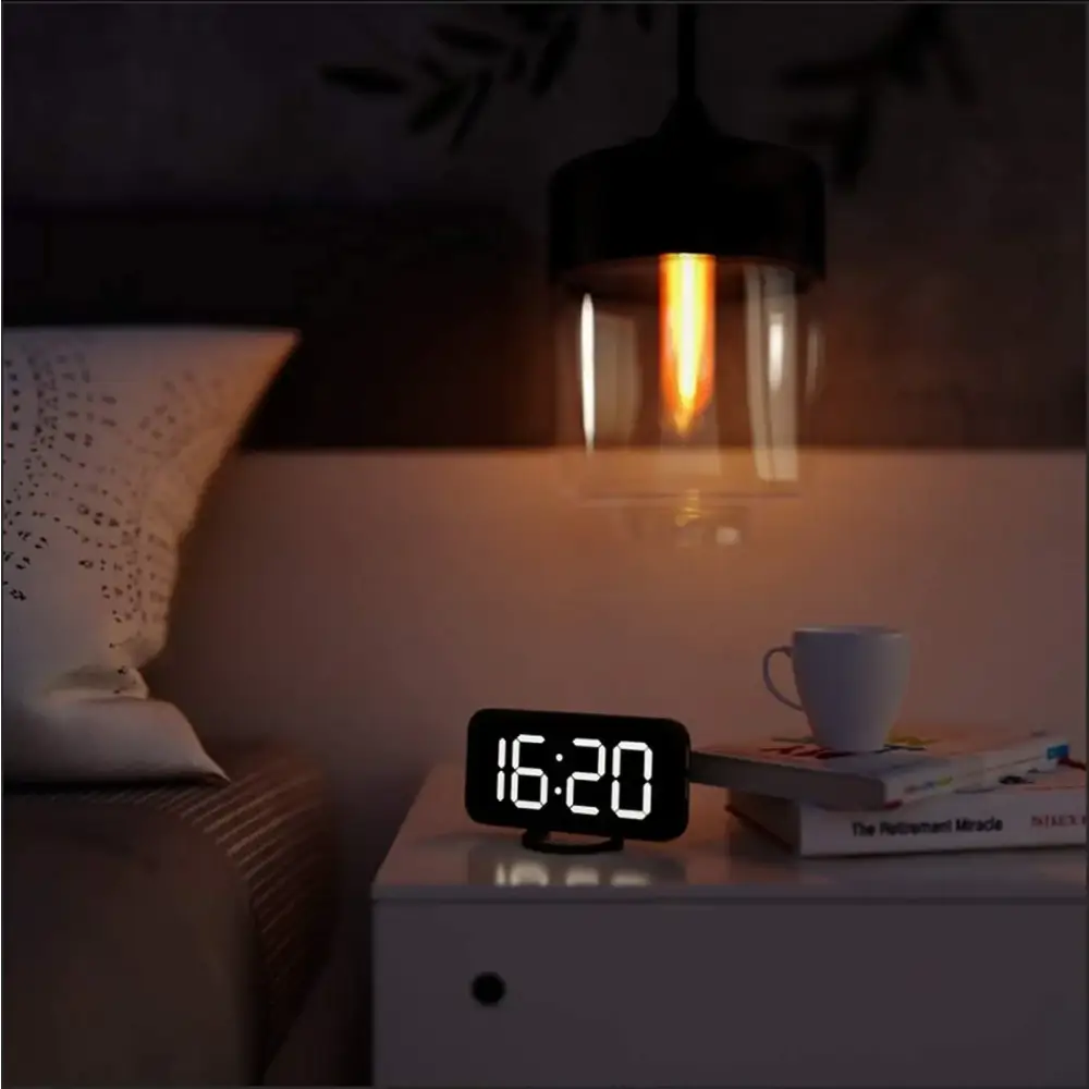 Black digital alarm clock with glowing white numerals displaying 16:20