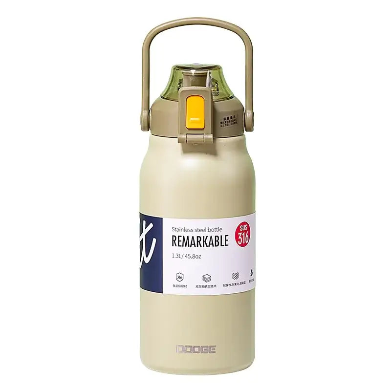 Beige stainless steel water bottle with a yellow flip-top lid and integrated handle, labeled ’remarkable’ by dodge.