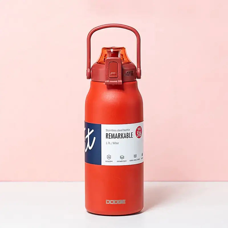 Red stainless steel water bottle with a matching handle and orange-tinted lid, featuring a white label that reads ’remarkable’ in bold black letters.