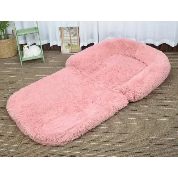 Pink fluffy pet bed with a soft, plush texture and rounded edges.