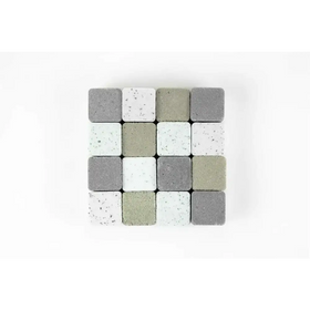 A collection of square concrete pavers in varying shades of gray, white, and beige with speckled textures.